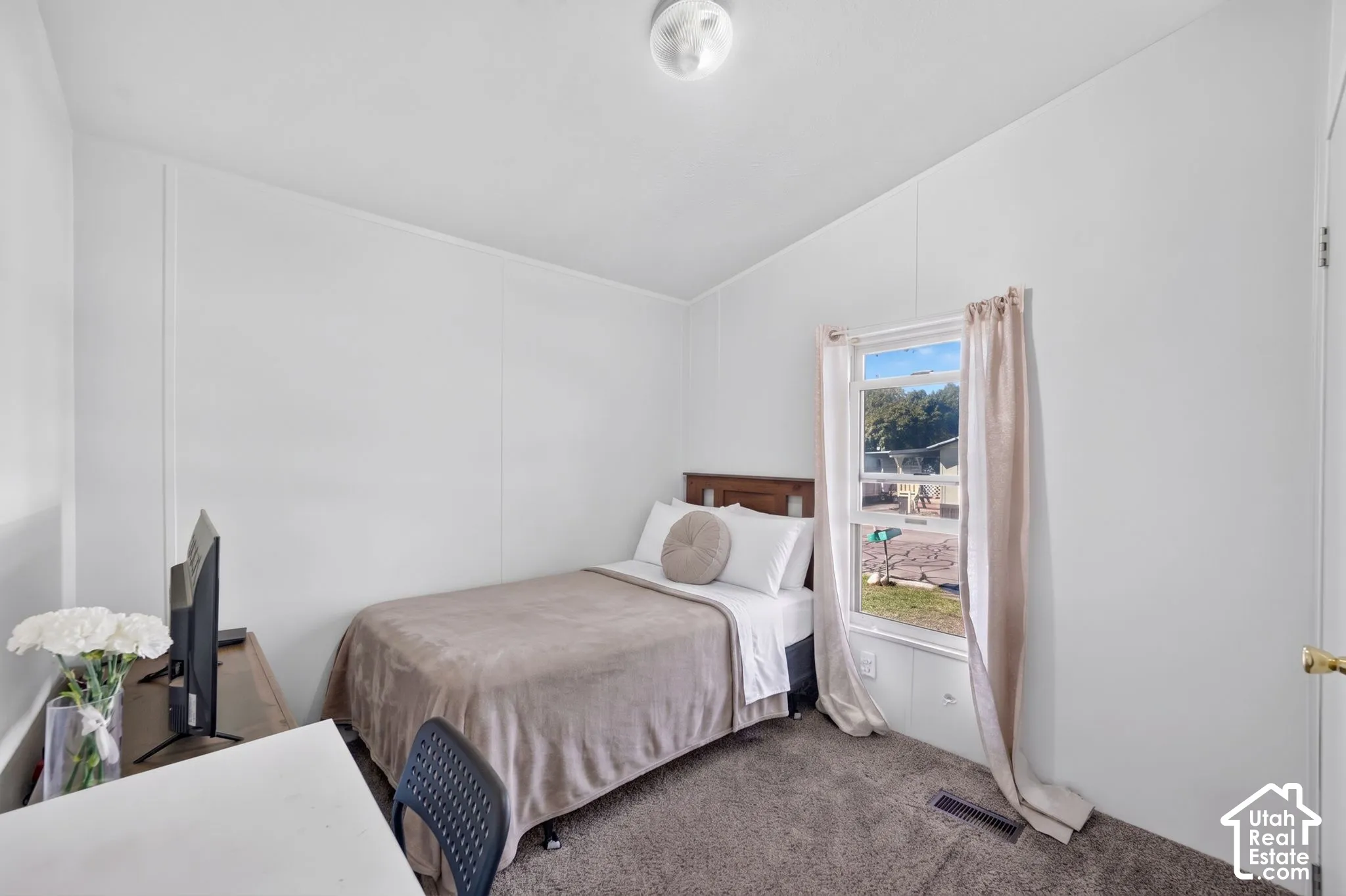 Carpeted flooring, white paneled walls, and a recessed window