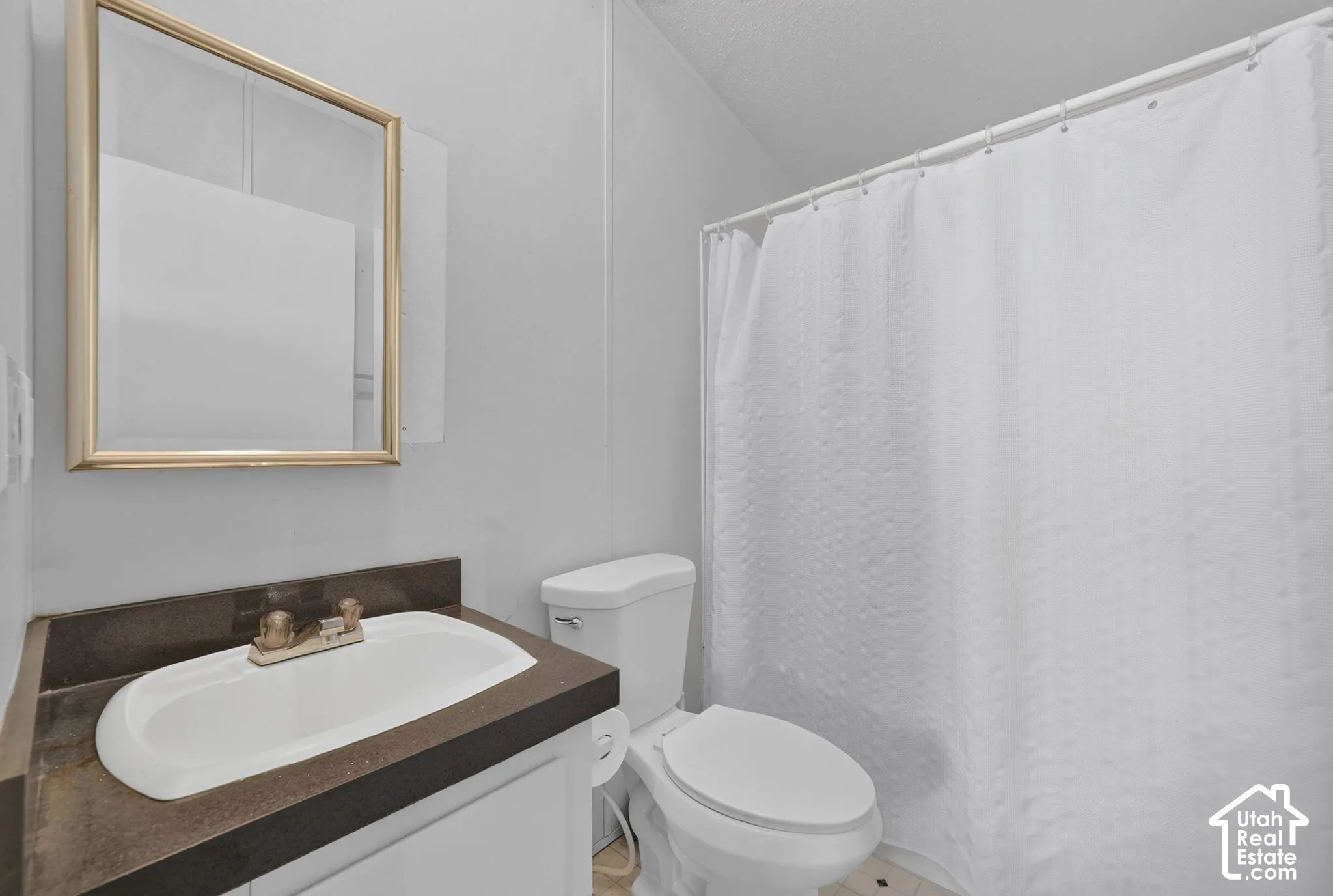 White vanity with an integrated sink and bronze-finish faucet