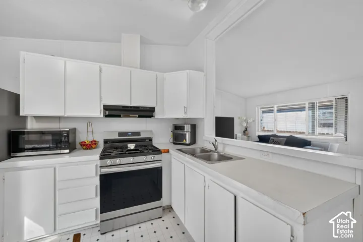 White cabinetry, stainless steel range, dual basin sink, and ample countertop space