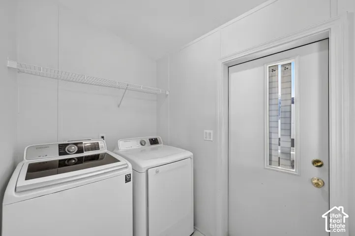 Laundry area featuring a white wire shelf, a white door with a window insert, and brass-tone hardware
