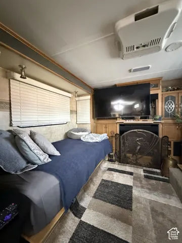 Recessed lighting, wood-finish cabinetry, built-in entertainment center, ceiling-mounted air conditioning unit, and Venetian blinds