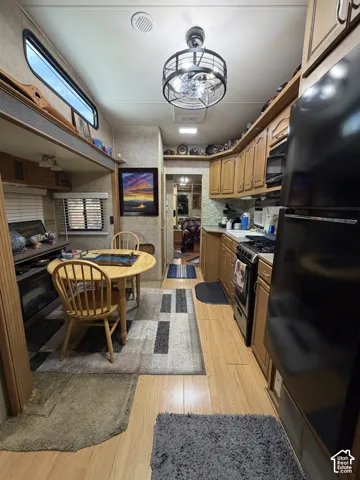 Wood-finish flooring throughout, full kitchen with gas range, integrated microwave, and refrigerator