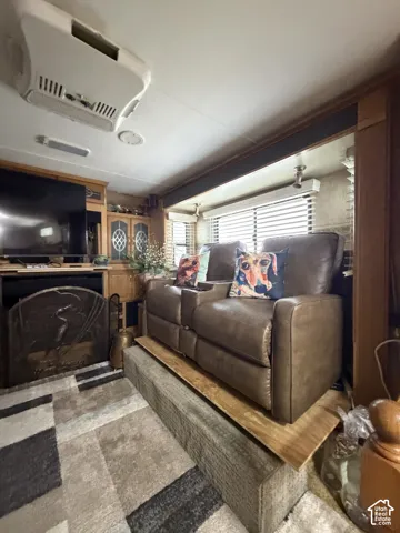 Built-in entertainment center, recessed lighting, ceiling-mounted air conditioning unit, window blinds, and wood-finish cabinetry
