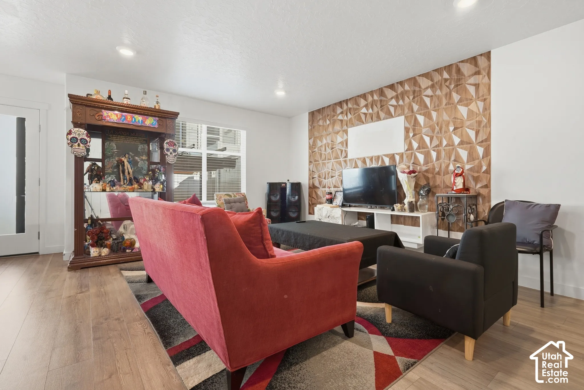 Wood-finish flooring throughout, recessed ceiling lighting, textured accent wall, and abundant natural light from large windows