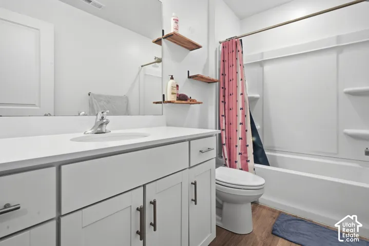 White vanity with shaker-style cabinetry, a white countertop, and an integrated sink
