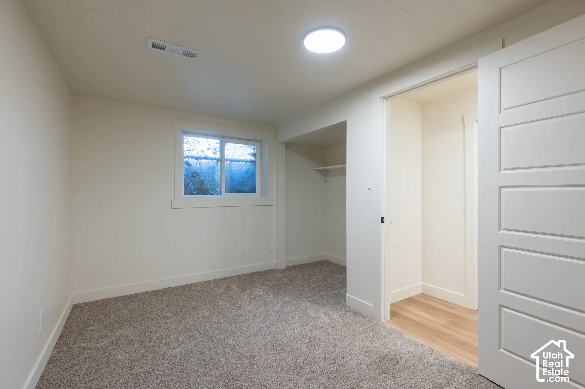 Carpeted flooring, recessed lighting, built-in shelving, white trim, and a white paneled door