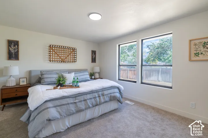 Neutral wall finishes, recessed ceiling lighting, two large windows, and wall-to-wall carpeting