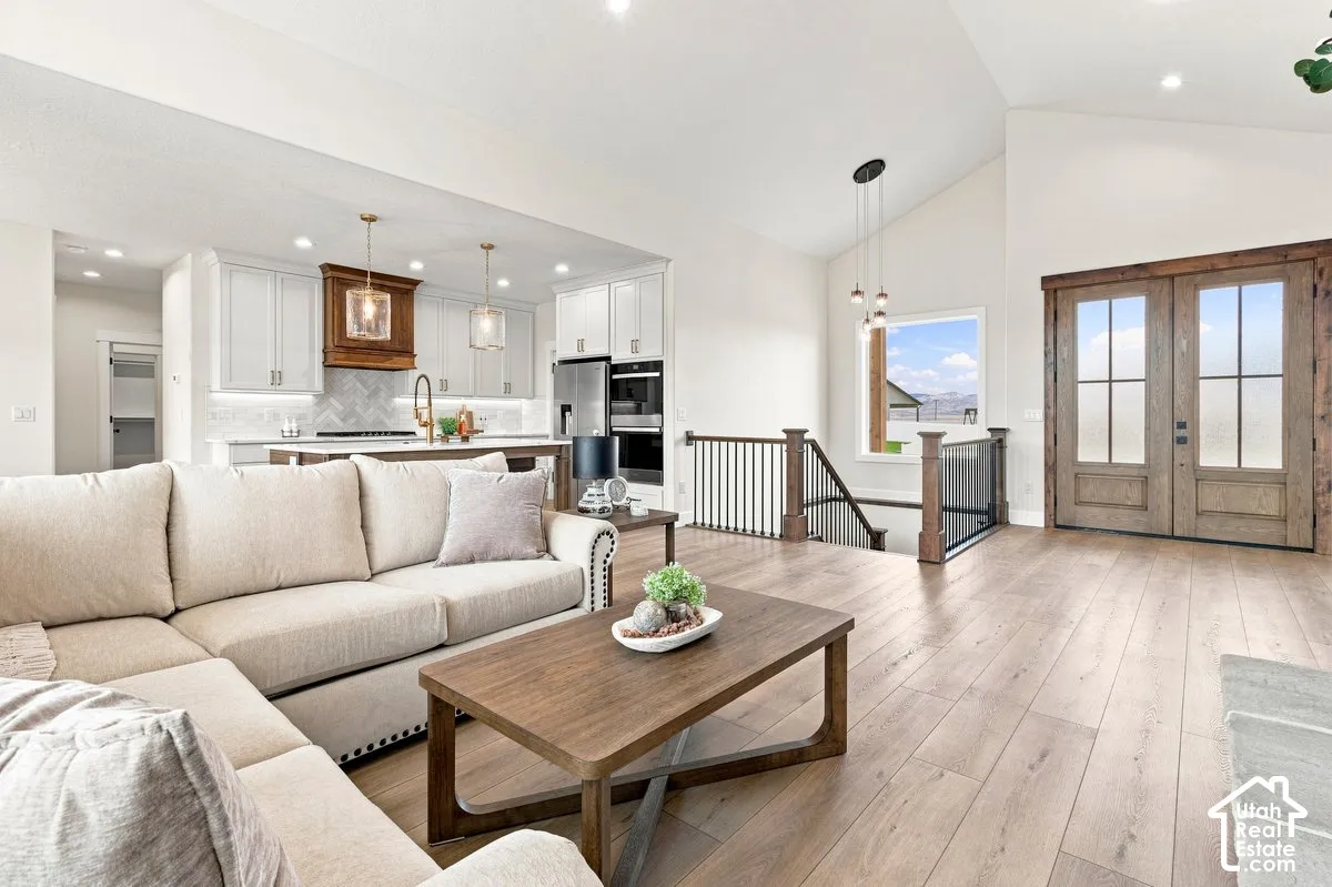 Open-concept living space featuring wood-finish flooring and vaulted ceilings