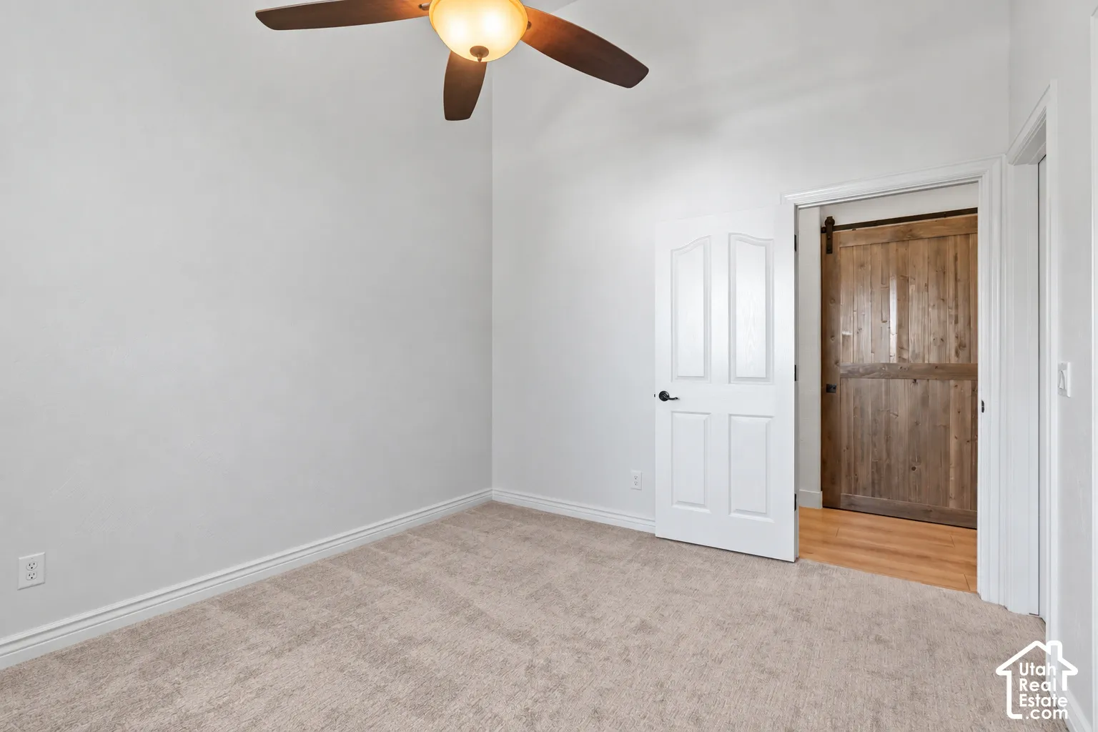 Neutral wall color, carpeted flooring, and a ceiling fan with integrated lighting