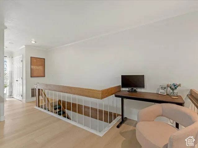 Light wood-finish flooring, white walls, and recessed lighting
