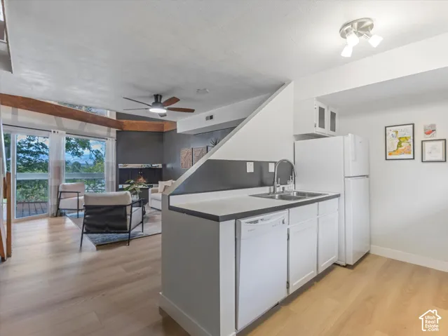 Open-concept living space featuring wood-finish flooring, a contemporary ceiling fan, and a kitchen with white cabinetry and a dual-basin sink