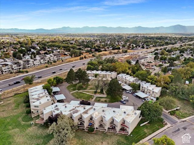 Residential complex with multiple buildings, surrounding green spaces, and adjacent roadways