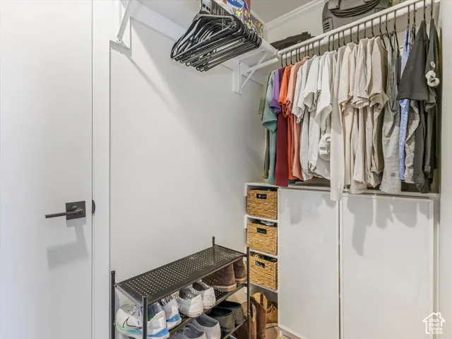 Integrated closet system with upper shelving, hanging rods, and built-in white cabinetry