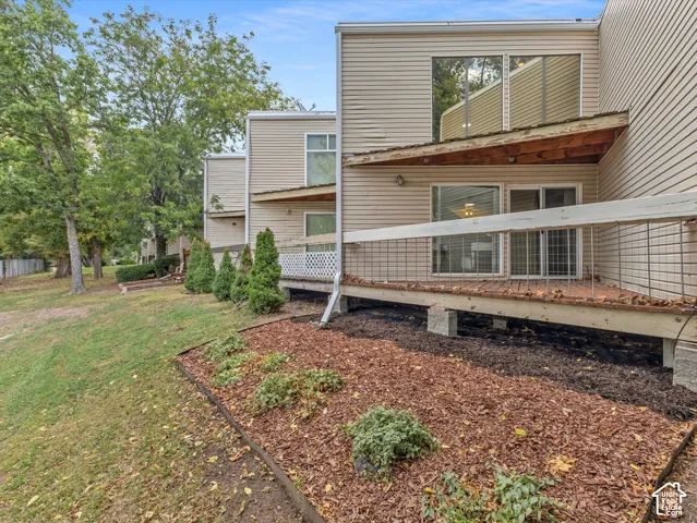 Exterior featuring siding, multiple windows, and a ground-level wood deck