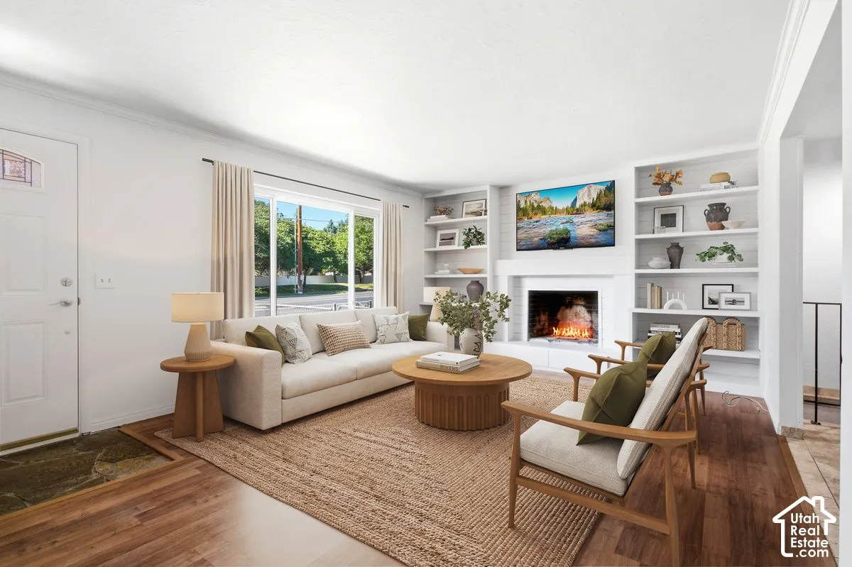 Living area with wood-finish flooring, a white paneled entry door, and a large window