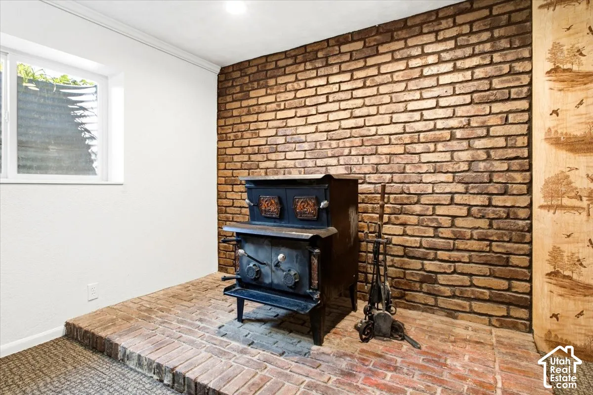 Brick accent wall with a built-in wood stove and brick hearth
