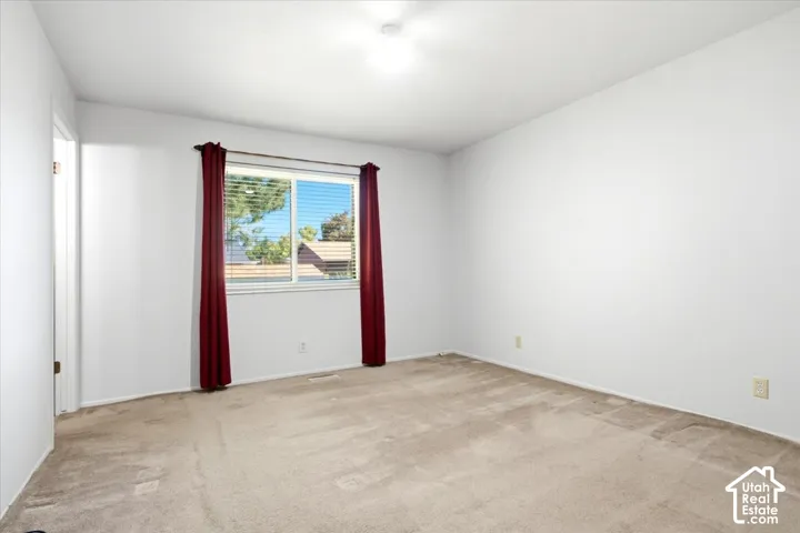 Master Bedroom Light-colored carpeting, white painted walls, and a single window with horizontal blinds