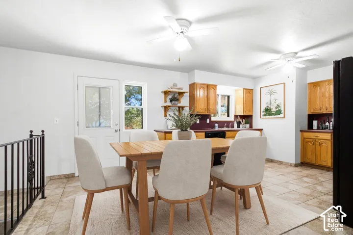 Tiled flooring, wood-finish cabinetry, black appliances, and a glass-paneled exterior door