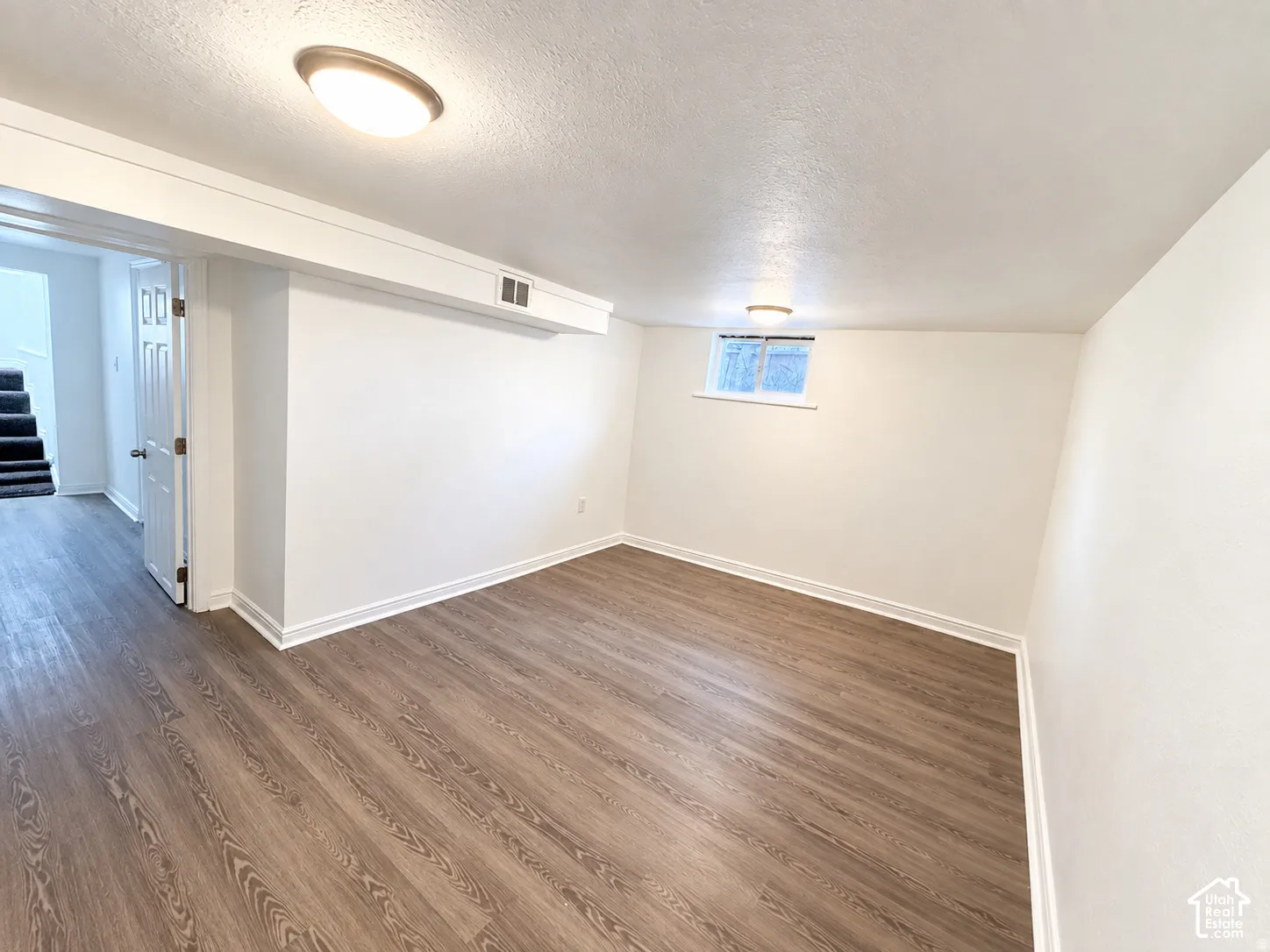 Wood-finish flooring, recessed window, overhead lighting, white walls, and white trim