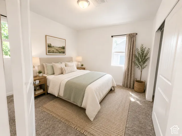 Recessed ceiling light, neutral carpet flooring, single window with curtains, sliding barn door, and a built-in closet