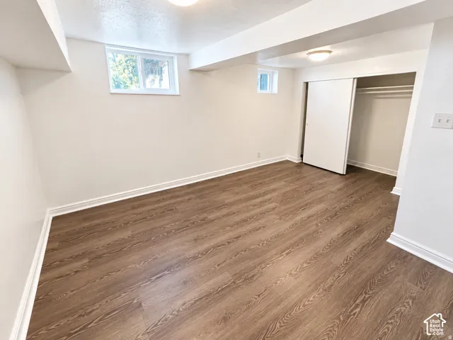 Wood-finish flooring, white walls, and a window providing natural light