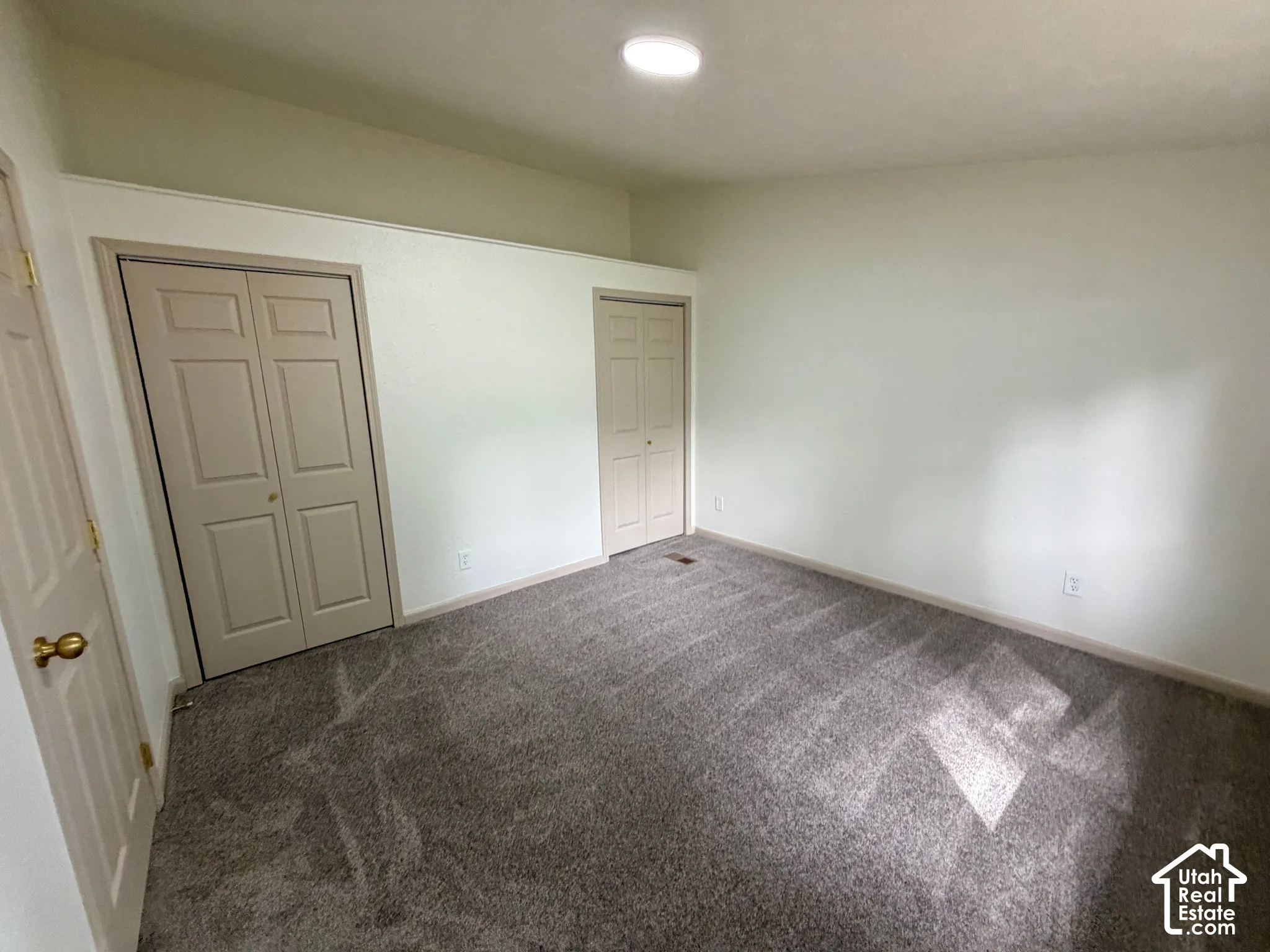 Recessed lighting, neutral wall paint, gray carpeting, and bi-fold closet doors
