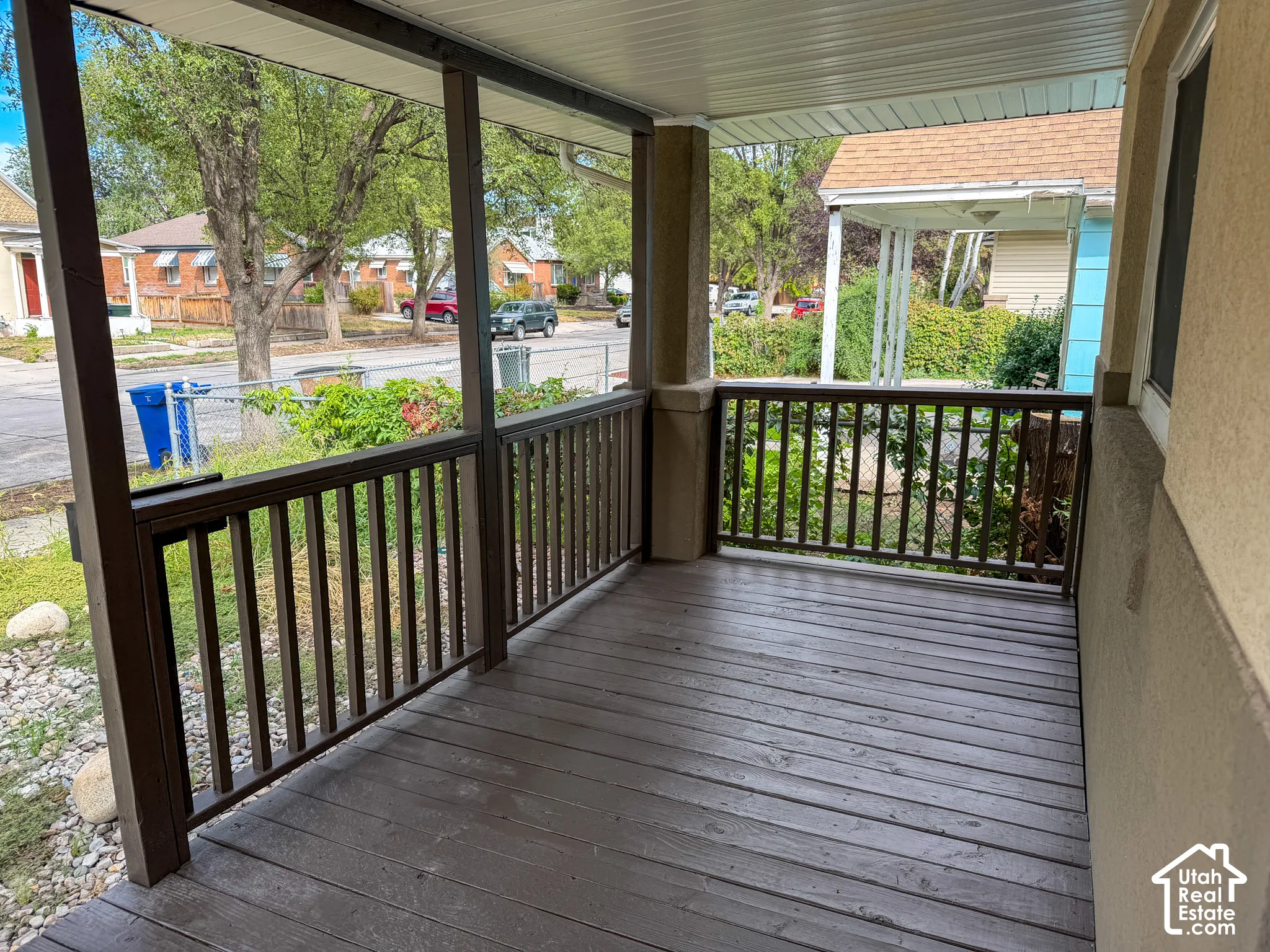 Covered porch with wood-finish decking and dark-stained railing