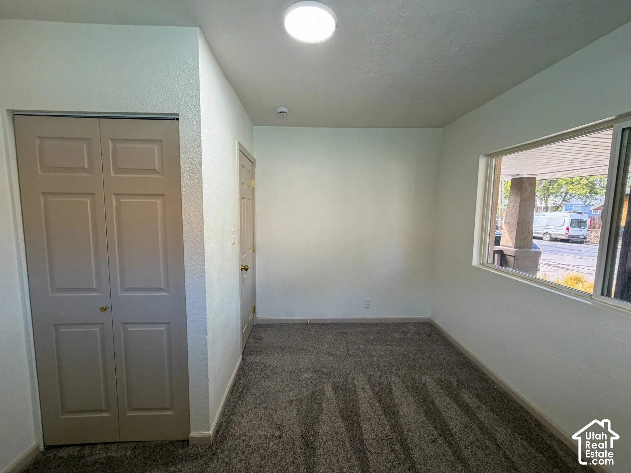 Neutral-toned walls complement the textured carpet flooring
