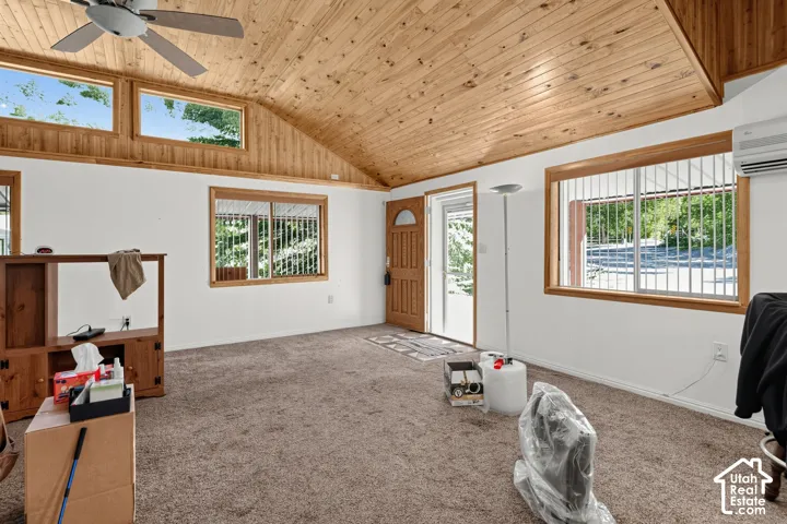 Vaulted wood-finish ceiling, wood-trimmed windows, and a ceiling fan with integrated lighting