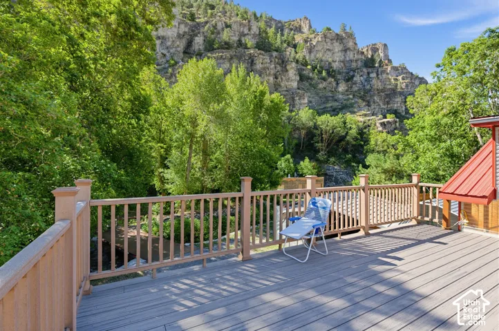 Spacious outdoor deck with composite decking, light wood-tone railings, and a red metal roof structure