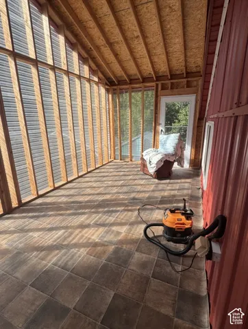 Enclosed porch with wood-frame walls, corrugated paneling, and a tiled floor