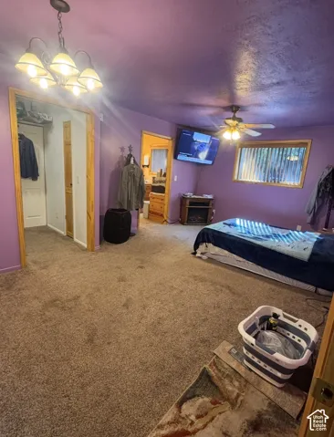 Ceiling fan fixture, recessed window, carpet flooring, wood-trim doorway, chandelier lighting