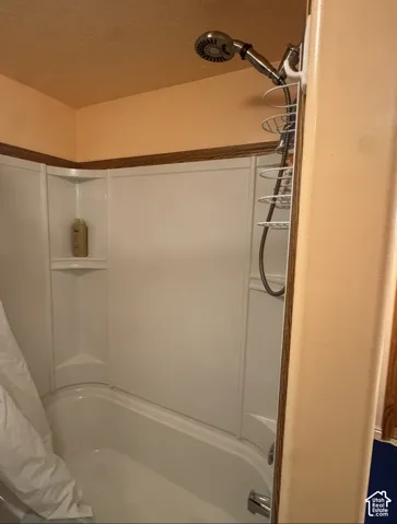 Bathtub with white surround and integrated corner shelving