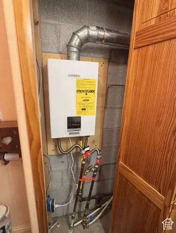 Wall-mounted water heater with exposed piping and ductwork