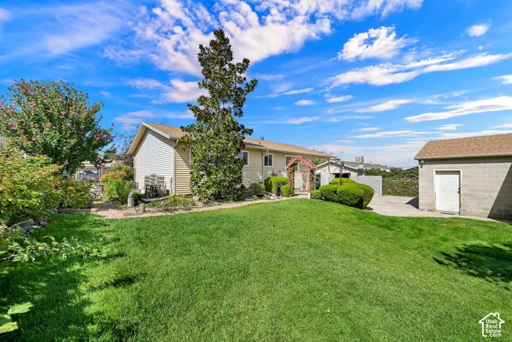 Expansive green lawn, mature trees, and a detached garage
