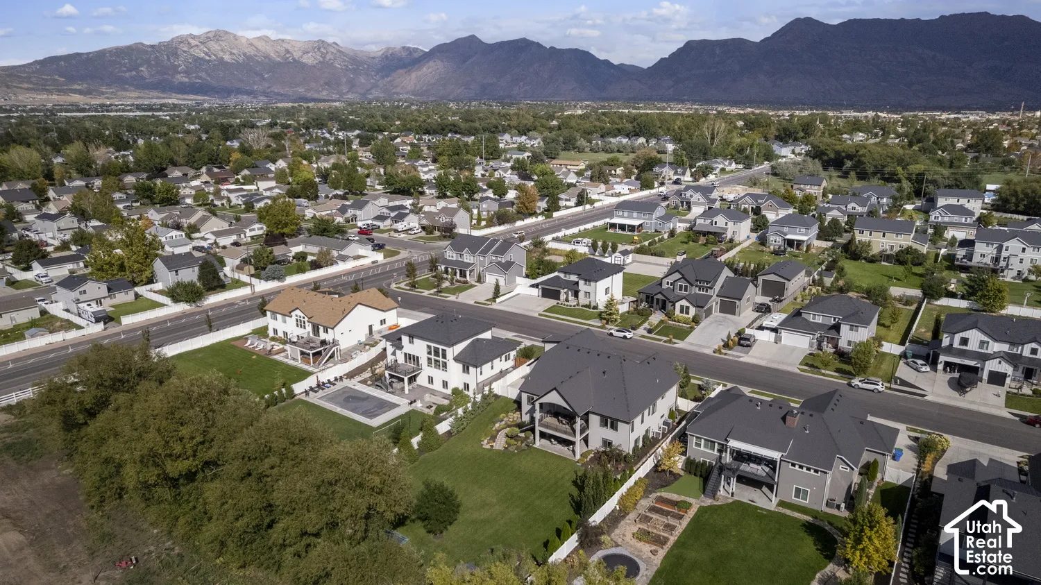 Expansive residential area featuring a variety of detached homes with distinct architectural styles, mature landscaping, and mountain scenery