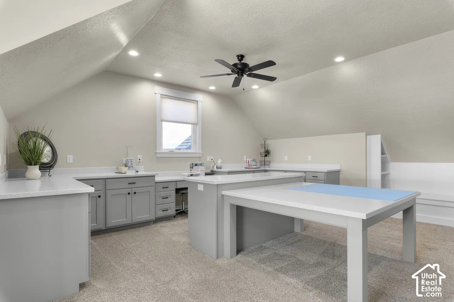 Angled ceiling with recessed lighting and a ceiling fan