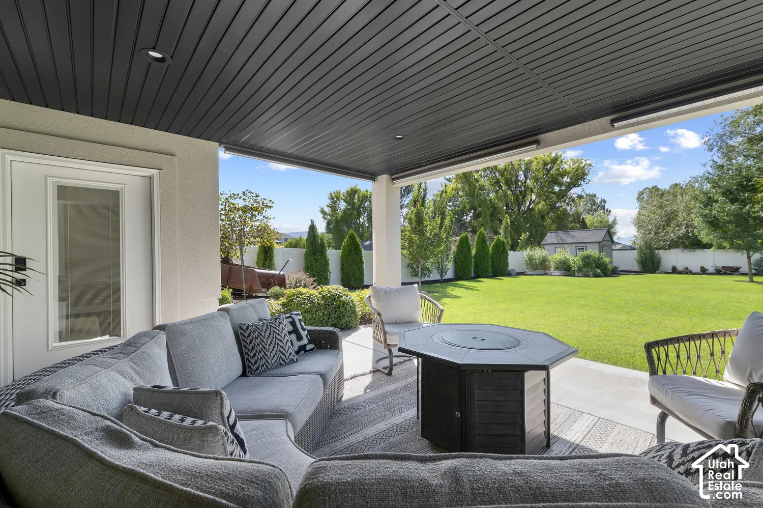 Covered patio featuring a slatted ceiling, recessed lighting, concrete flooring, and a manicured lawn