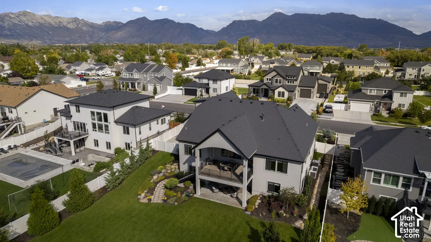 Expansive backyard with a manicured lawn, paved patio.
