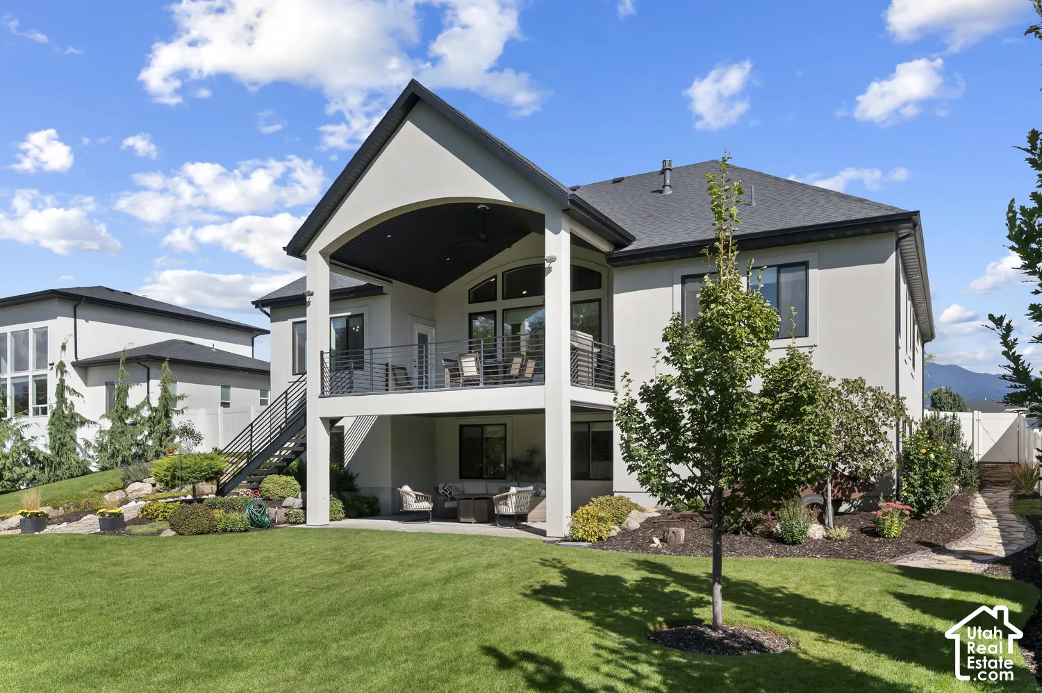 Multi-level exterior featuring a covered deck with metal railings and an additional covered patio