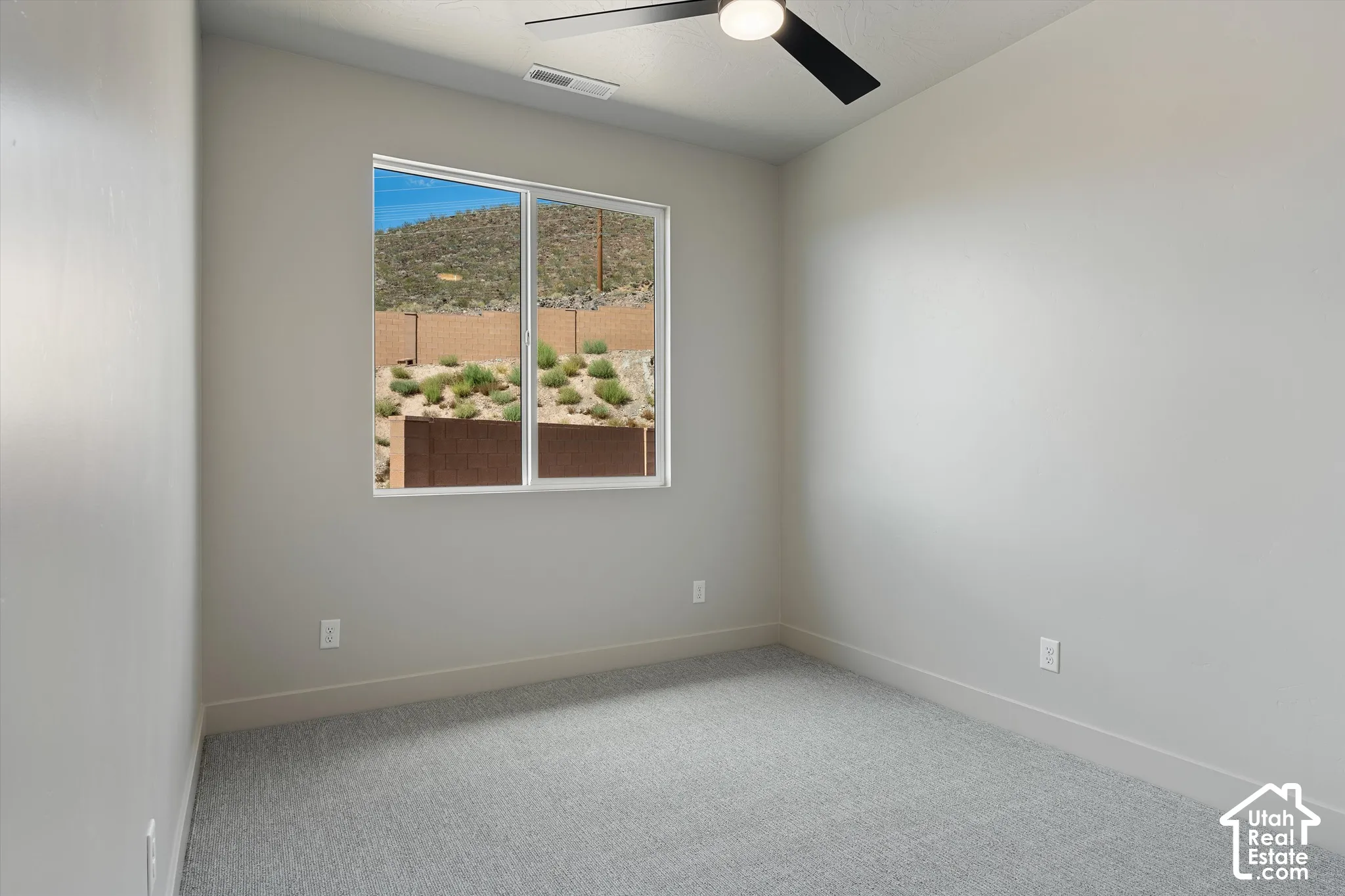 Neutral-toned walls complement the grey carpet flooring