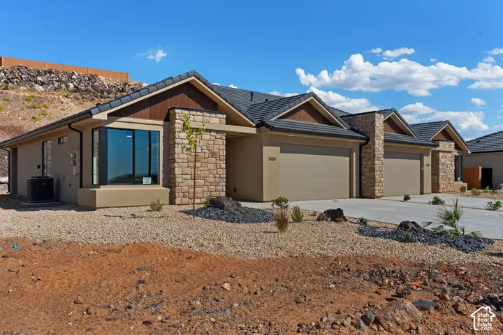 Modern exterior featuring a prominent bay window, stone accents, and a multi-car garage with individual doors