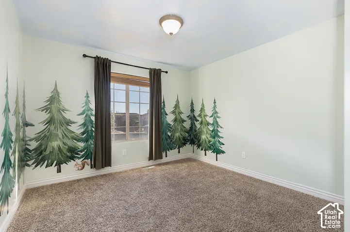 Carpeted room with a multi-pane window, flush-mount lighting, and wall murals
