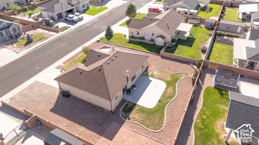 Expansive backyard featuring a manicured lawn, concrete patio, and gravel landscaping