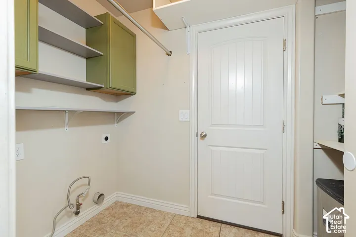 Tile flooring, wall-mounted shelving, built-in cabinetry, and a paneled door