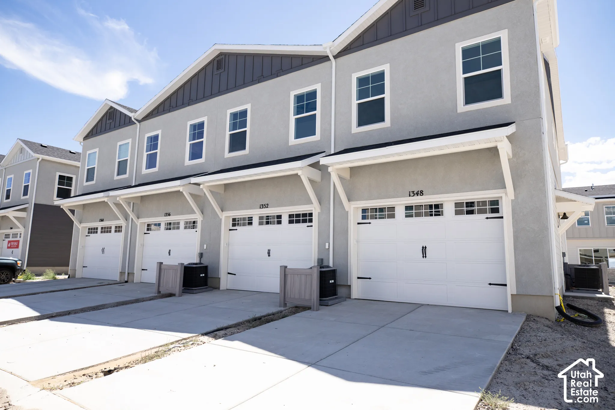 Rear view of townhouse building garage with extended driveway.