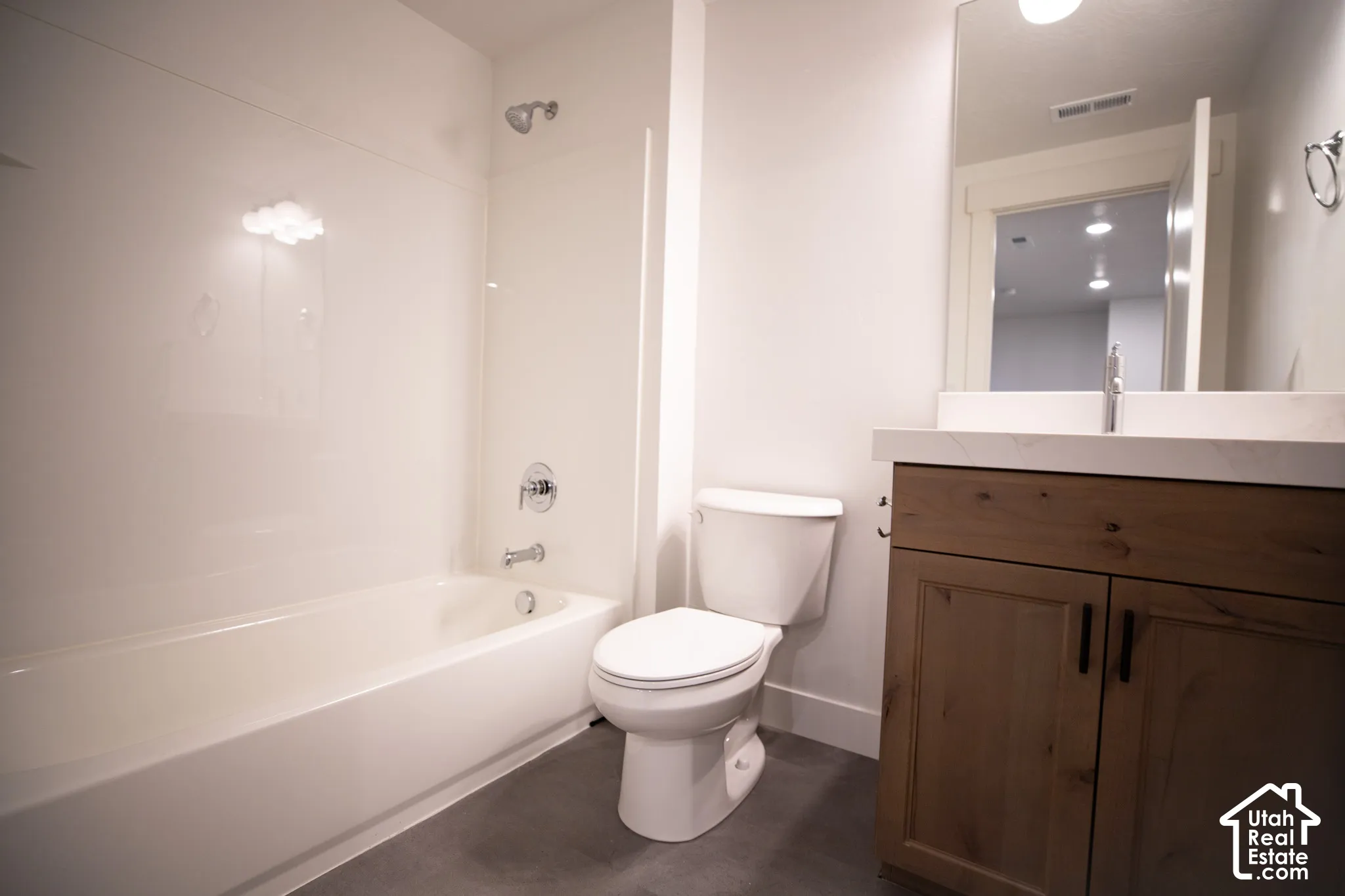 Third full bath with stained wood cabinet and quartz slab countertops as part of fully-finished basement.