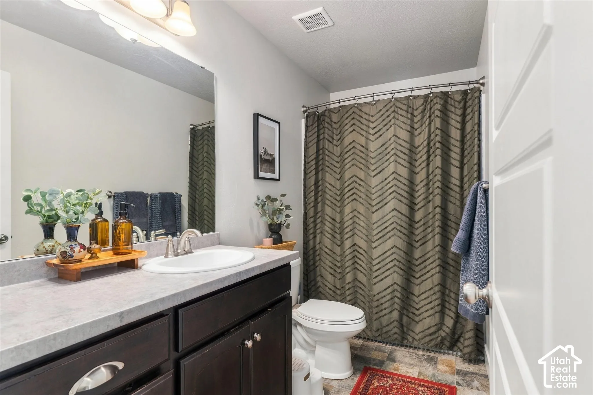 Vanity with dark wood cabinetry and a light-toned countertop