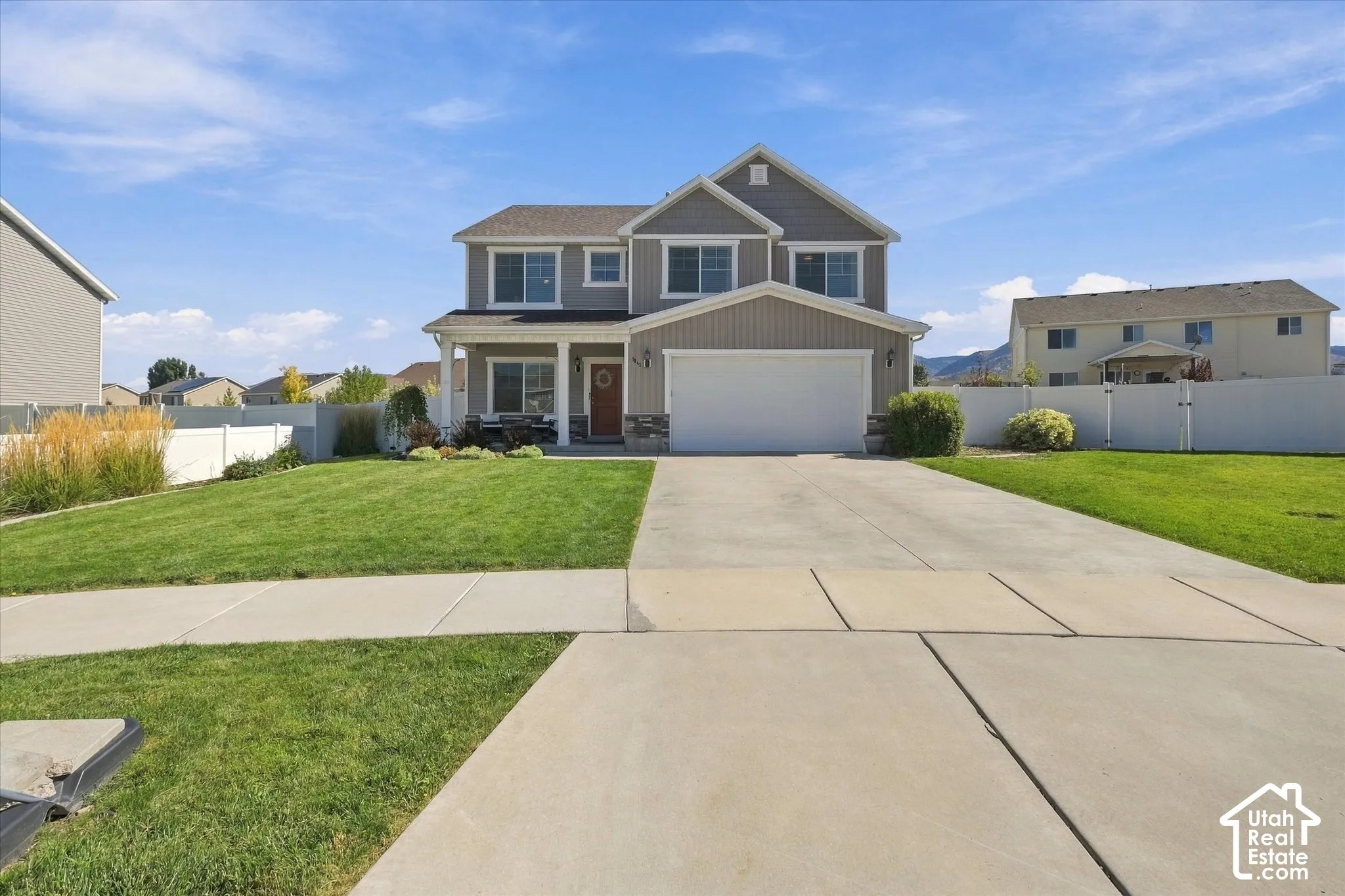 Two-story residence featuring a covered front porch, an attached two-car garage, and a concrete driveway