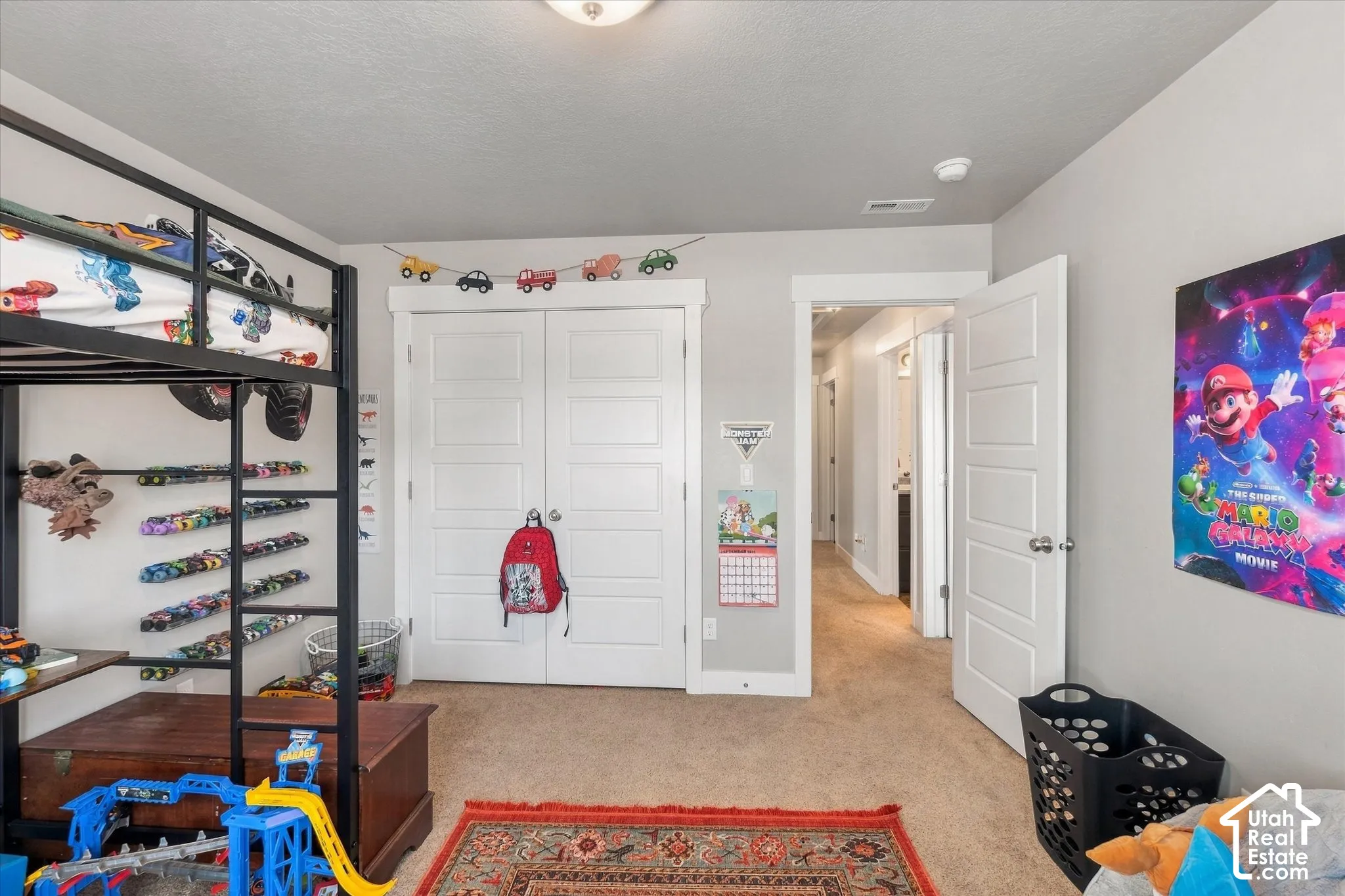 Carpeted flooring with light gray walls, featuring a five-panel interior door, and a built-in closet with double doors